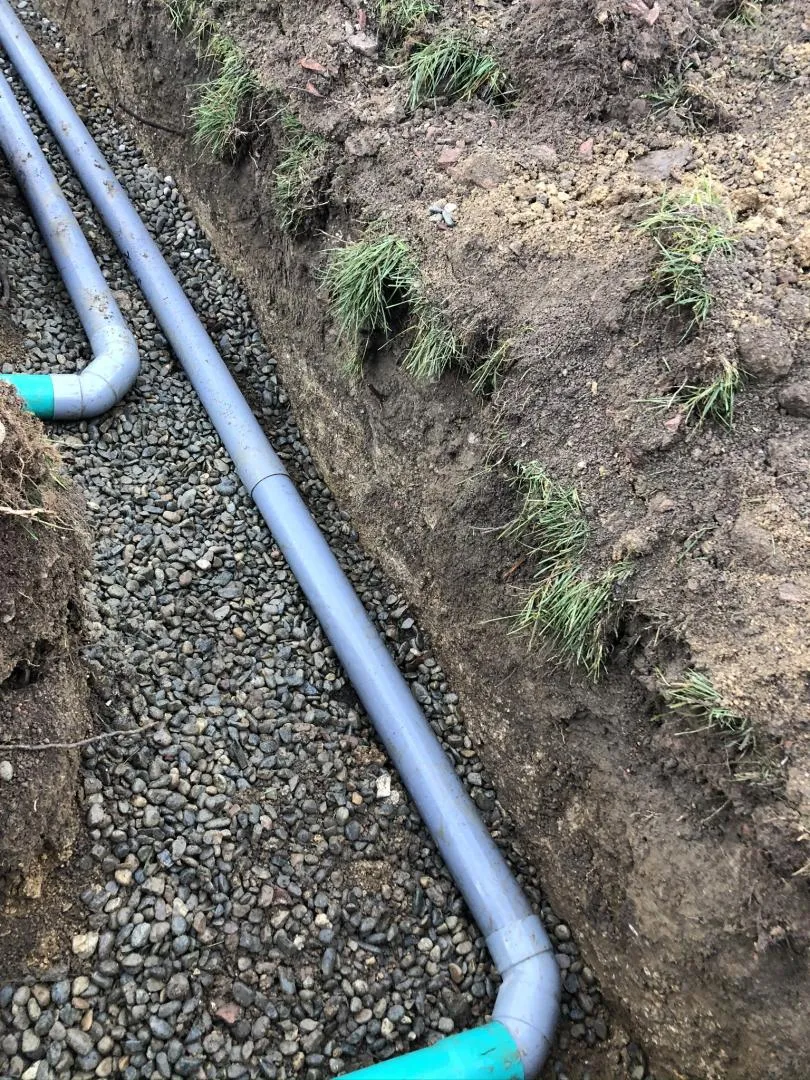 Tuyaux de drainage installés dans une tranchée, réalisés par une entreprise d'assainissement. ​​