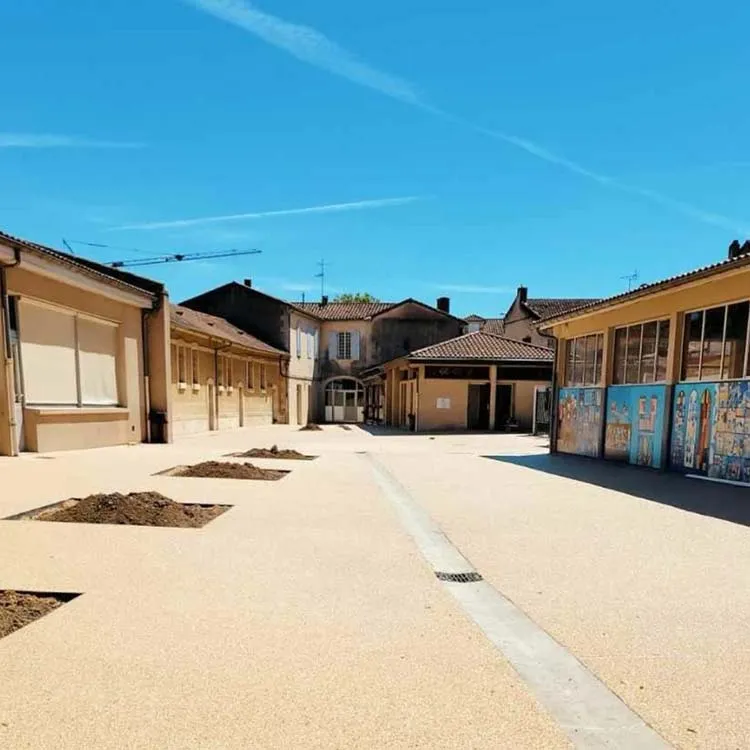 Vue d'une allée pavée après des travaux réalisés par une entreprise VRD, avec des bâtiments environnants.